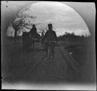 Thomas Allen on his bicycle passing a cart on the road to Bukhoro, Uzbekistan, 1891