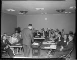 Group of men in a meeting, and roast on spit cooking under infra-red lights