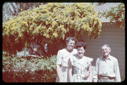 Three Adults in Front of A Garden Home