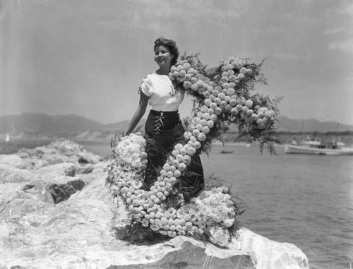Young woman holding flower arrangement