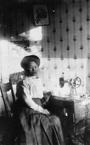 Japanese American woman at sewing machine