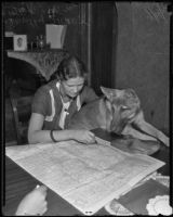 Dorothy Skaer with her dog, Duke, reading a map, Los Angeles, 1935