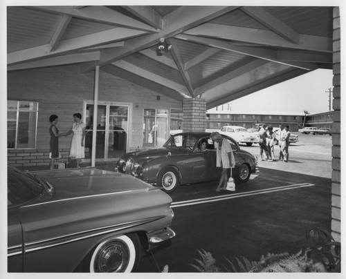 Outdoor Main Entrance Area of the Oxnard MoteLodge with Cars and Guests