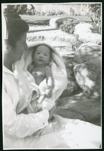 Photograph of Irene Gavigan, R.N., holding a newborn at Manzanar