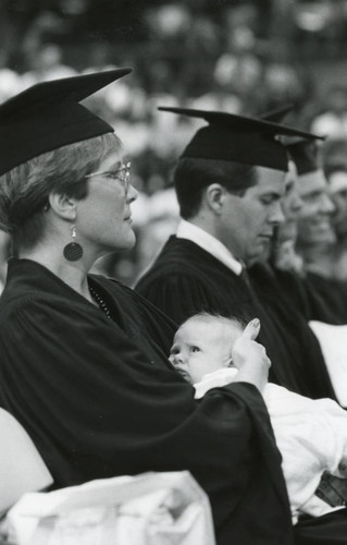 Woman seated with her baby and the representative of the Class of '85 next to her