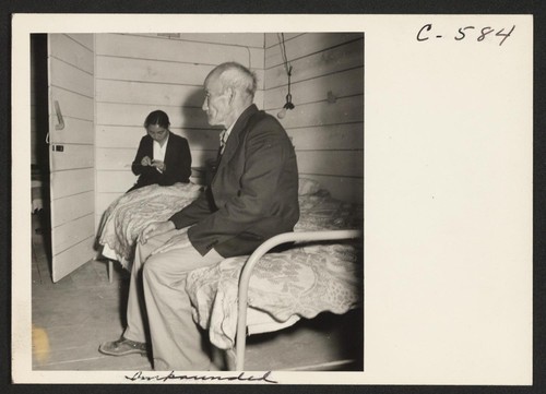 Old Mr. Konda in barrack apartment, after supper. He lives here with his two sons, his married daughter and her
