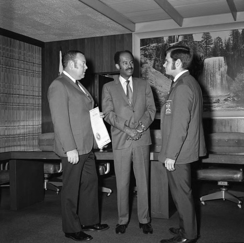 Three unidentified men talking together in a lounge at Compton College, Los Angeles, ca. 1972