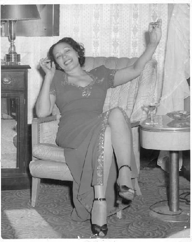 Unidentified woman wearing evening gown sitting in chair