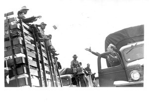 "Lunchtime For Japanese Convoy--Enroute to their new homes in a reception center at Manzanar, California, Japanese traveling in an auto convoy paused in the Mojave desert for a box lunch provided by soldiers who accompanied them"--caption on photograph