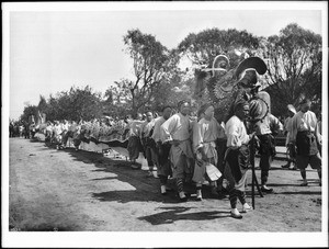 Men who man the Chinese Dragon for La Fiesta de Los Angeles standing beside it, ca.1900-1908