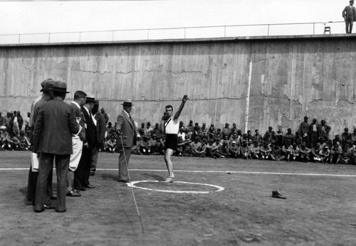 Shot-put event, with officials looking on, San Quentin Little Olympics Field Meet, 1930 [photograph]