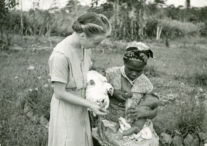 Fang woman giving her milk, in Ebeigne, Gabon
