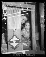 Woman at loom with child at the Los Angeles Indian Center 2920 Beverly Blvd. in Los Angeles, Calif., 1954