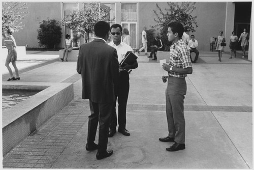 Students gather on campus outside Benson Center, ca. 1965