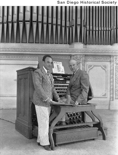 Organist Royal A. Brown seated at the Spreckels Organ with an unidentified man