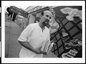 Man carrying books outside Christian Center, Boyle Heights Christian Center, Los Angeles, 1999