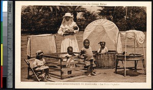 Missionary sister with orphans in wooden cribs, Niangara, Congo, ca.1900-1930