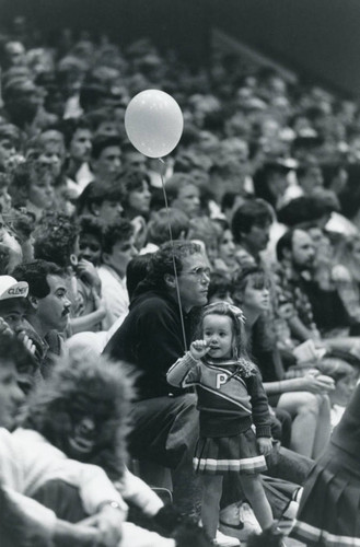 Girl with balloon at basketball game, 1984