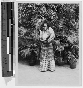 Smiling Filipina carrying clay jug, Philippines, ca. 1920-1940