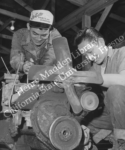 George Baba and Tokiji Umeda overhauling a truck loader in motor pool repair section at Rohwer Relocation Center