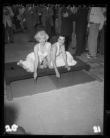 Marilyn Monroe and Jane Russell putting signatures in cement at Chinese Theater, Hollywood (Los Angeles), 1953