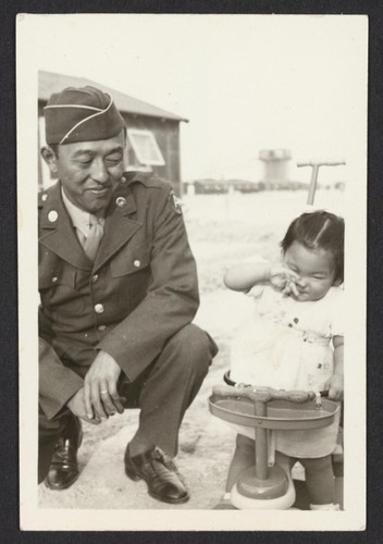 Uniformed soldier with his daughter.