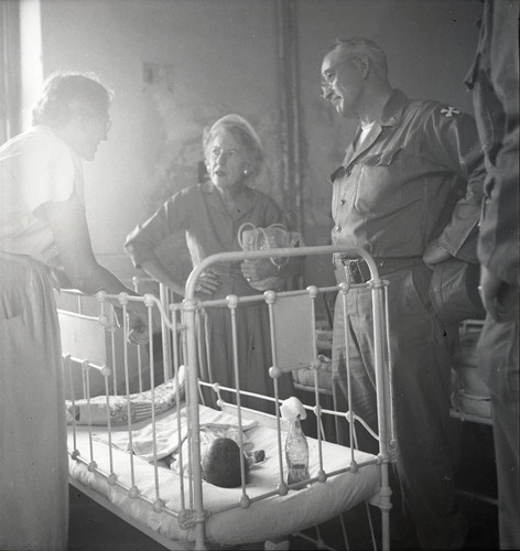 Maurine Clark visiting a baby in a crib