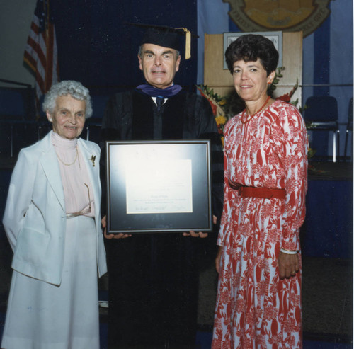 Robert Hood, holding his Award, and his mother and wife