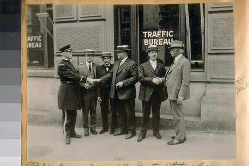 Police Convention of the United States & Canada, held at S.F. [San Francisco], Calif., June 19th to 24th, 1922. Photo taken in front of the Traffic Bureau Office, S.E. cor. Washington & Dunber Alley. L. to R.: Capt. H Gleeson on the left & J.B. Cook on the right end
