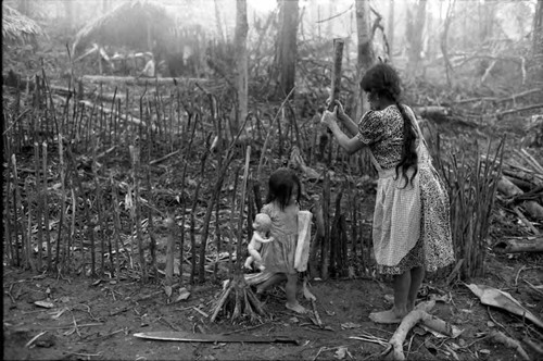 Refugee woman builds a fence of logs, Chiapas, 1983