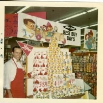 Interior view of the Stop N Shop grocery store owned by the Kassis family. This view shows a clerk standing next to a display of Libby's canned goods