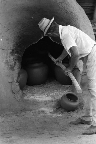 Man operating an oven, La Chamba, Colombia, 1975