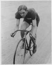 Harding K. Downing riding bicycle in velodrome