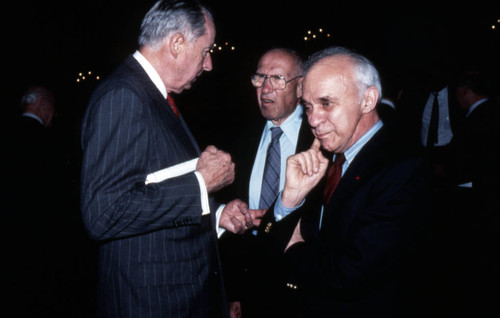 Peter Drucker standing between two individuals