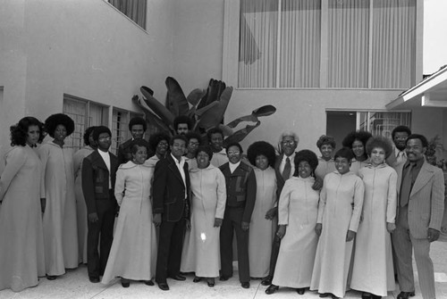 Bayard Rustin posing with a choral group, Los Angeles, 1973