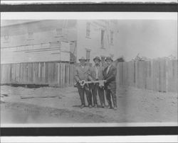 Lyman Byce and 2 men holding a large key, Petaluma, California, 1902