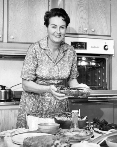 Mrs. Harry Kohms serves luncheon