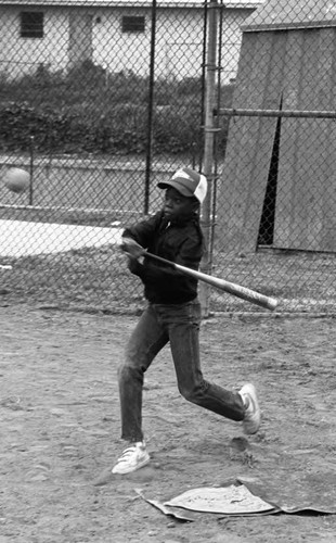 Boy hitting a ball during Cub Scouts Little League opening day, Los Angeles, 1986