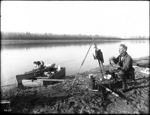 Professor William Judson painting a picture on the bank of the Colorado River during a trip with George Wharton James, ca.1910