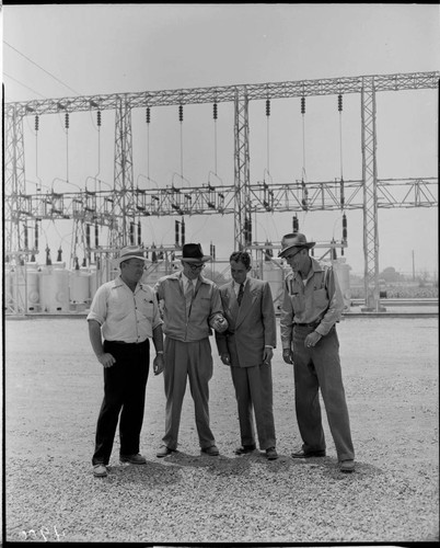 Four men standing in front of substation dead end