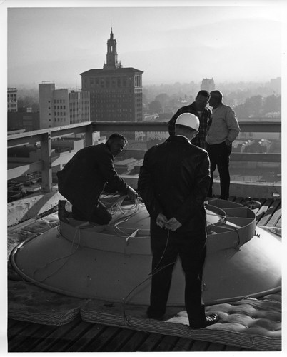 Image of Four Men Installing a Telephone Company Rooftop Satellite