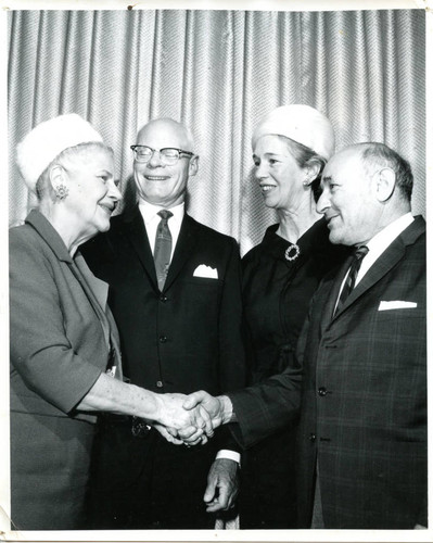 Two men and two women shaking hands