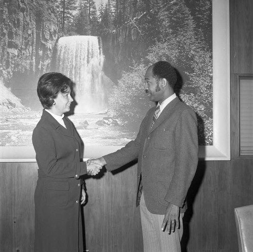 Man and woman shaking hands during an event at Compton College, Los Angeles, ca. 1972
