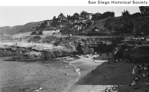 Adults and children on the sand and in the water at La Jolla Cove