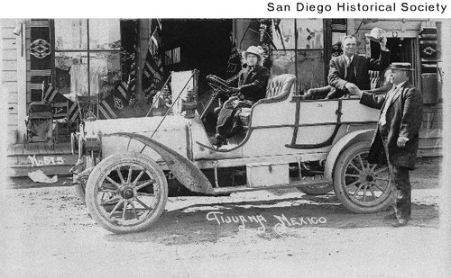 Charles Sloane in an automobile shaking hands with the Mayor of Tijuana, with Blanche Burtt at the wheel