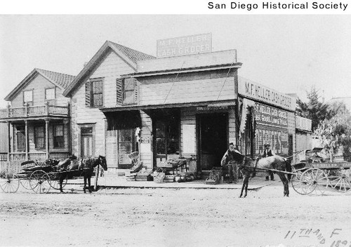 Two horse-drawn carts outside the M.F. Heller grocery store at Eleventh and F Street