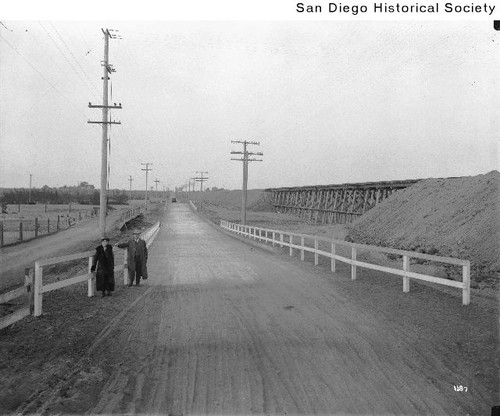 A man and a woman standing along a fence in Otay Mesa