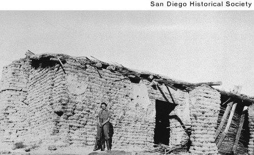 A woman standing outside the ruins of the Vallecito Stage Coach station