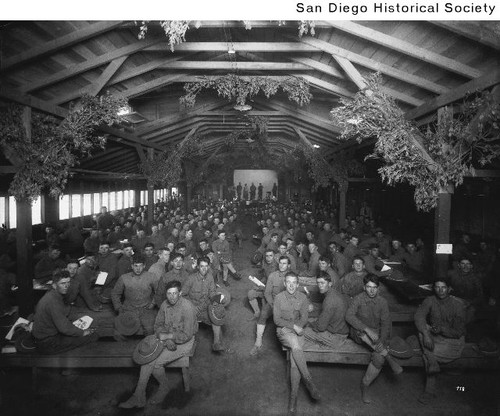 Soldiers seated in a recreation hall at Camp Kearny