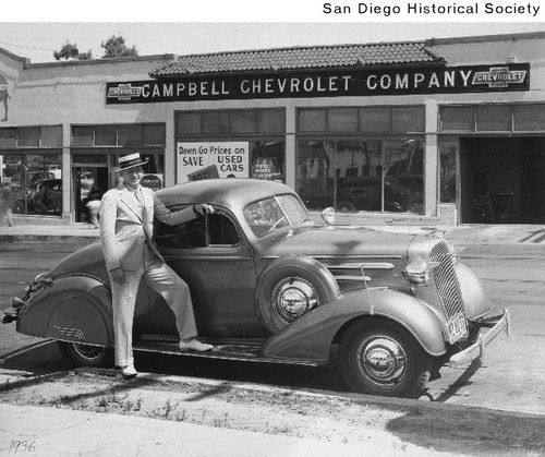 Larry Imig standing next to a Chevrolet automobile parked in front of the Campbell Chevrolet Company